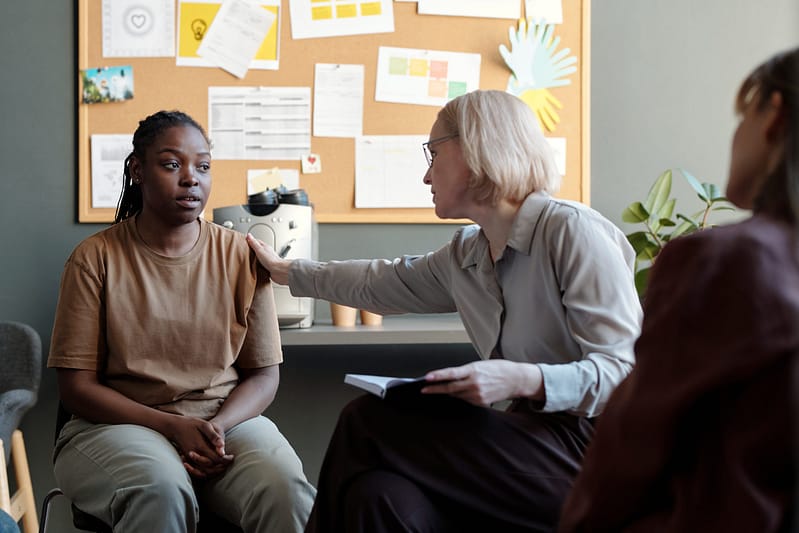 comforting a girl during a therapy session, showing the need for billing services for mental health